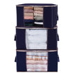 Stack of navy blue storage bags with clothes inside on a white background