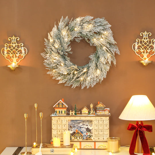 60cm Flocked Pre-Lit Christmas Wreath hanging in a festive room