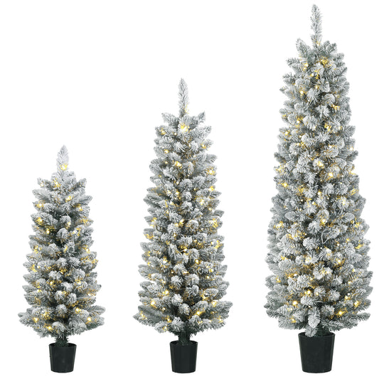 Set of three slim snowy pre-lit pencil Christmas trees glowing with warm white LEDs