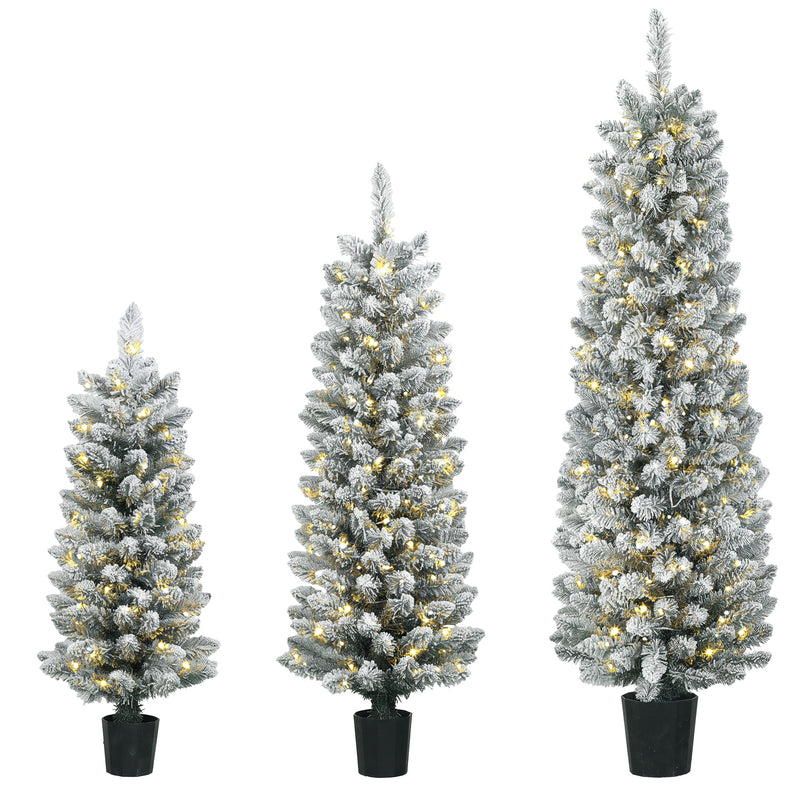 Set of three slim snowy pre-lit pencil Christmas trees glowing with warm white LEDs