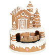 Musical gingerbread house Christmas decoration with snowy roof, trees and miniature train on a white background