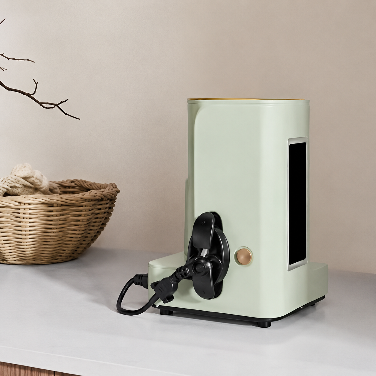 Light green cylindrical device with black components on a white surface, with a beige wall and wicker basket in the background.