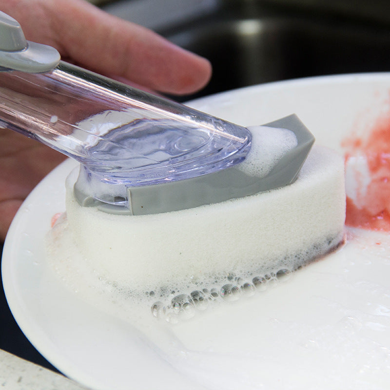 Person using a scrubber with soap on a plate in a kitchen setting