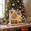 Gingerbread house beside a Christmas tree