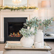 Astor Large Distressed Mirrored Tray with Wood Trim – 80cm, mirrored tray styled with vases on a coffee table by a fireplace