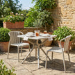 Axis putty grey chairs around a bistro table on a sunny patio