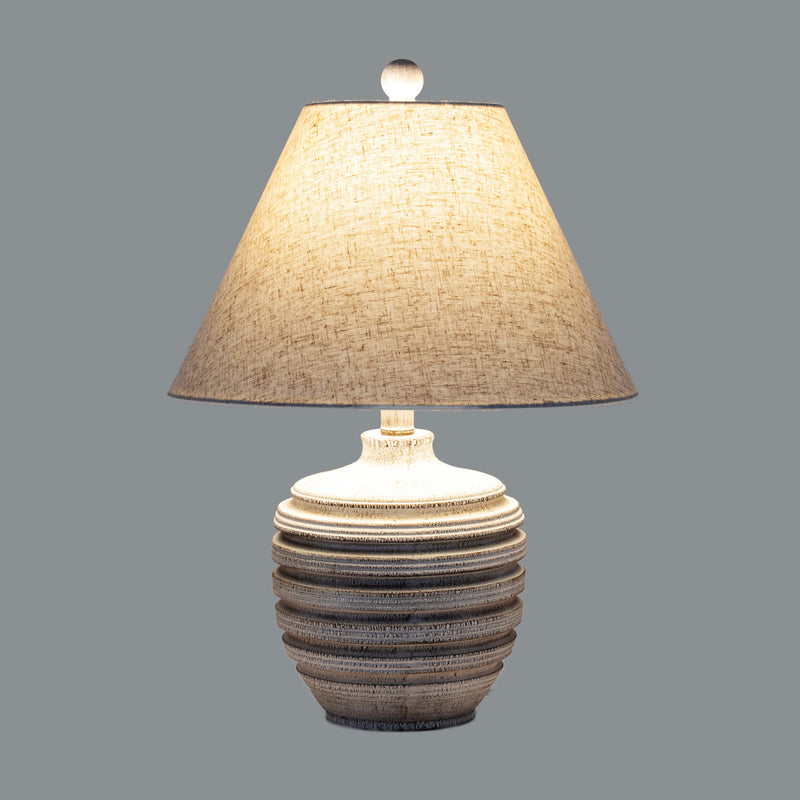 Beacon table lamp switched on against a grey background