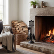 Black companion set beside a lit fireplace