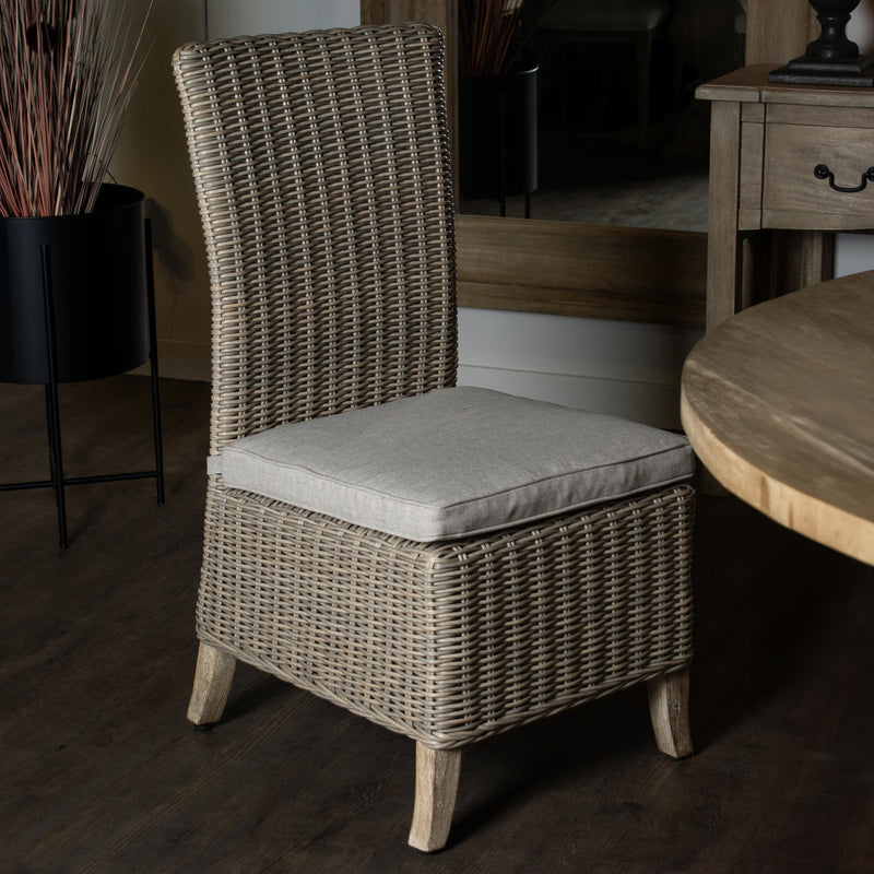 Capri wicker chair beside a dining table indoors