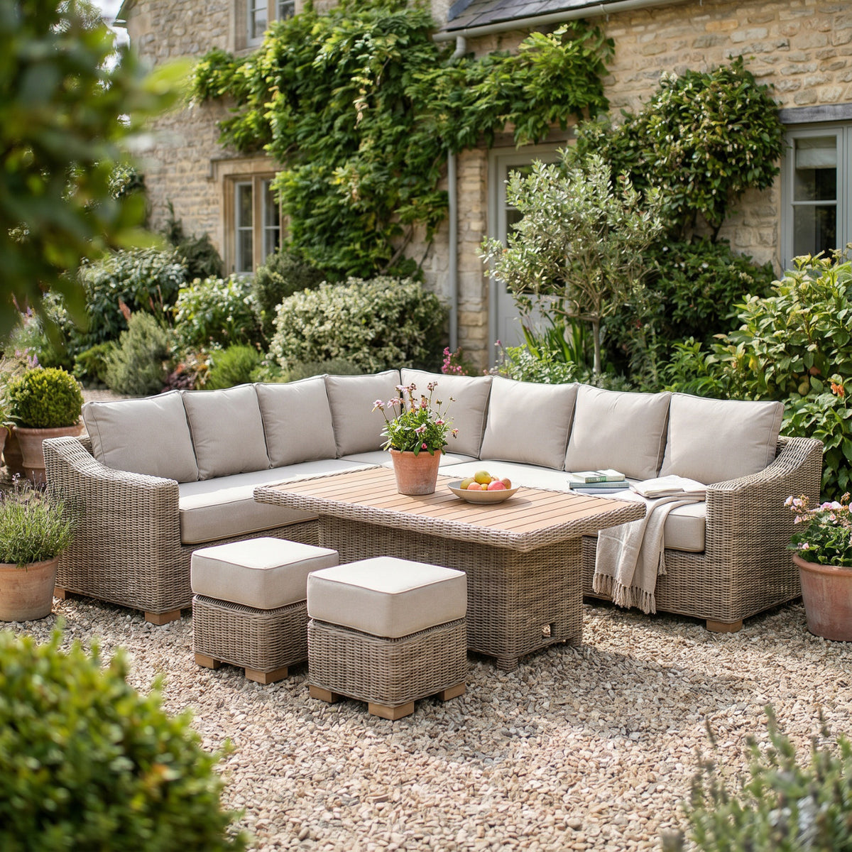 Capri wicker corner sofa set with riser table and stools in a cottage garden