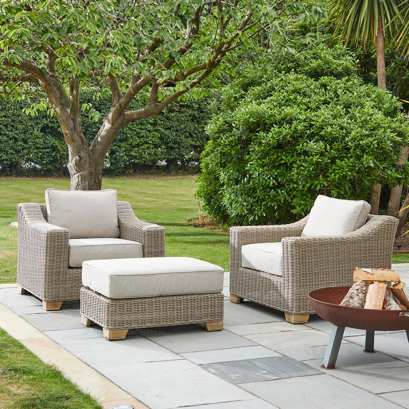 Capri footstool between two wicker armchairs in a garden, chairs sold separately