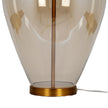 Gold-tone foot and cable at the base of the glass lamp