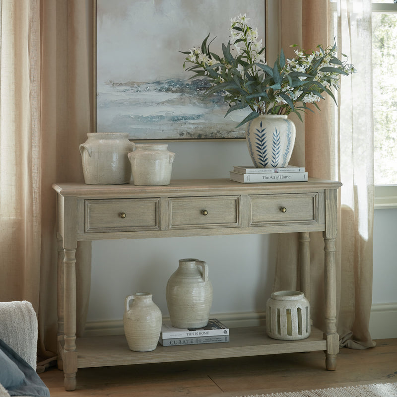 Delphine console styled with vases under artwork
