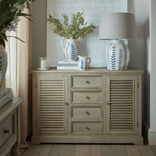 Delphine dresser base used as a sideboard with a lamp and vases