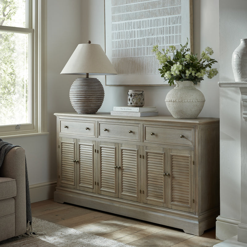 Delphine dresser base used as a sideboard with a lamp and vases