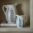 Close-up of jugs and books on the inside shelf