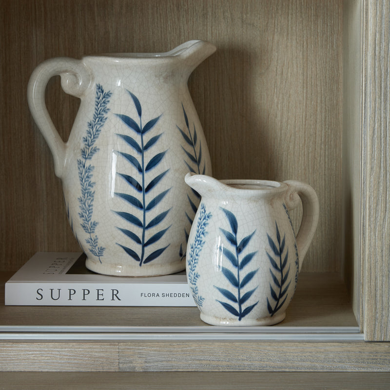 Close-up of jugs and books on the inside shelf