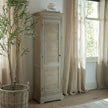 Delphine tall cabinet in a bright bedroom beside a window
