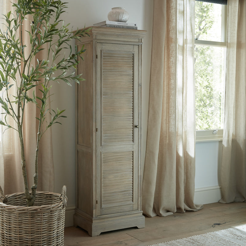 Delphine tall cabinet in a bright bedroom beside a window