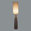 Dune floor lamp switched on against a grey background
