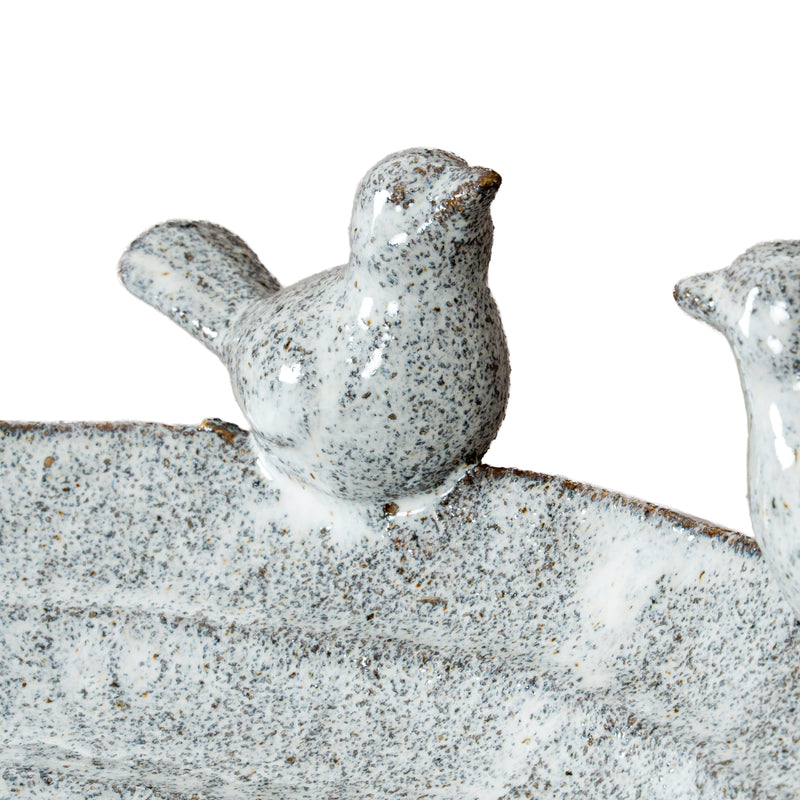 Close-up of a speckled ceramic bird on the rim