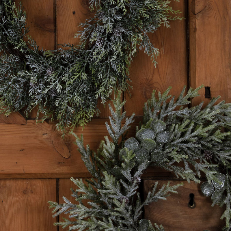 Frosted Pine Christmas Wreath with Pinecones – 55cm, frosted wreaths styled on a rustic wooden door
