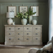 Haldon chest in a living room with table lamps, vases and botanical prints