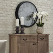 white orchid on a wooden sideboard below a wall clock