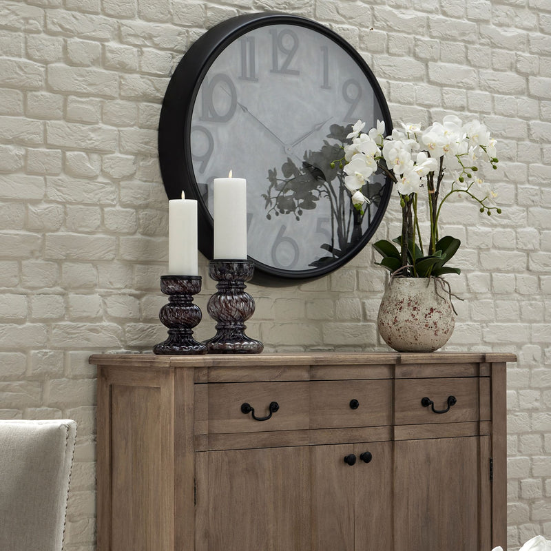 white orchid on a wooden sideboard below a wall clock