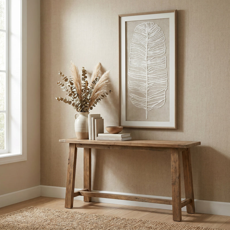 Plume feather art hung above a wooden console table