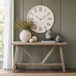 Rustic white clock above a wooden console table