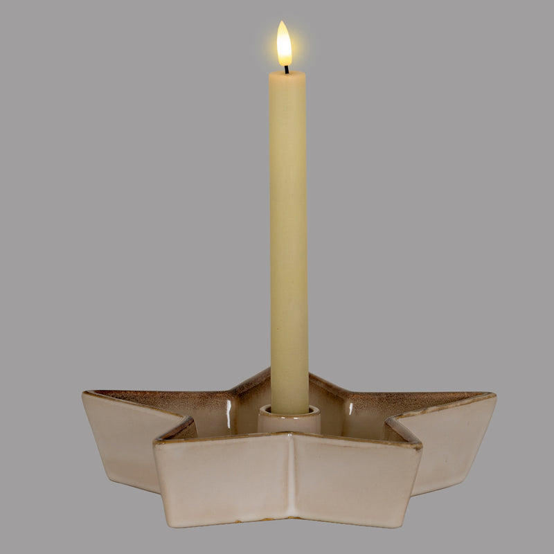 Star candle holder with a lit dinner candle