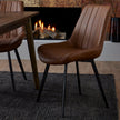 Malmo Tan Faux Leather Dining Chair with Black Legs, tan dining chair beside a table near a log fire