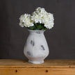 Naxos vase holding white hydrangeas on a wooden table