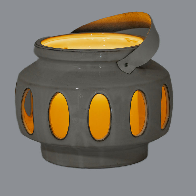 Novi oval window lantern glowing with a candle inside