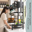 Woman washing dishes in a kitchen with a dish rack and cleaning supplies.