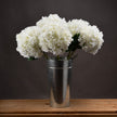 White hydrangea stems in a metal vase, vase and extra stems sold separately