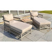 Two Provence sun loungers with oatmeal cushions and the acacia table, side angle