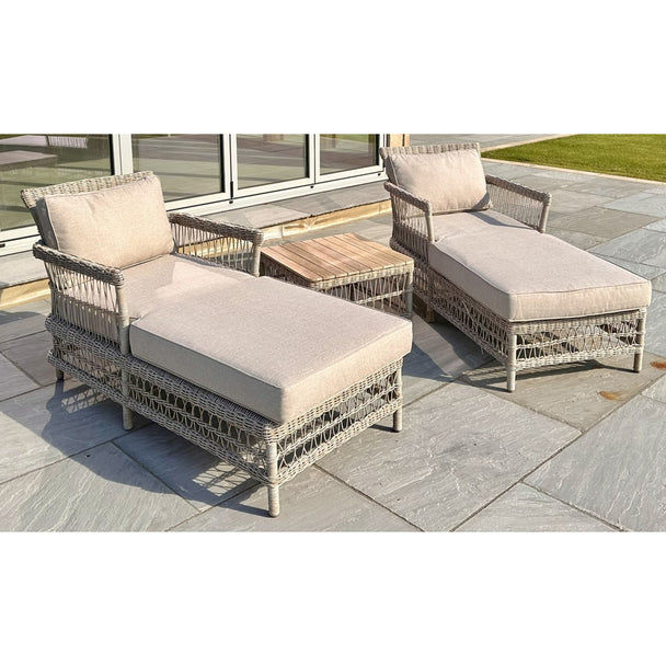 Two Provence sun loungers with oatmeal cushions and the acacia table, side angle