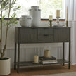 Reed console styled with vases and candlesticks by a window