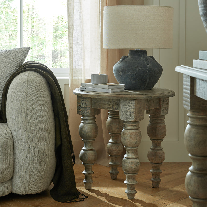 Rutland round side table beside a sofa with a lamp