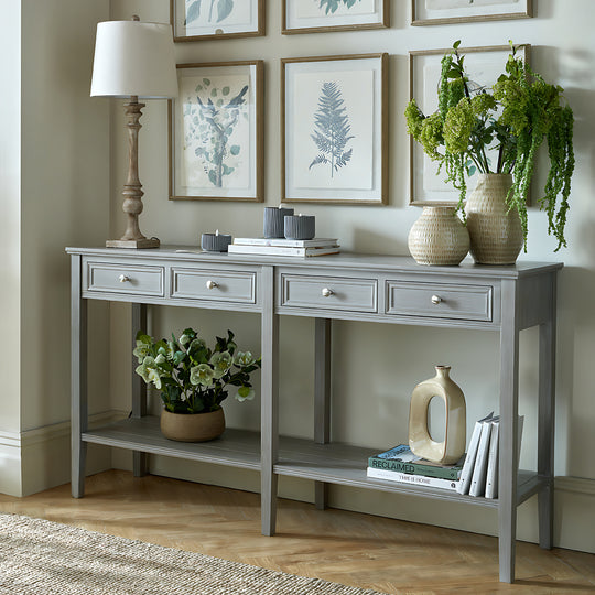 Serene grey four-drawer console table in a hallway with framed prints and plants