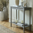 Grey console table with rattan shelf styled in a hallway