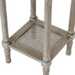 close-up of the woven rattan lower shelf and turned legs