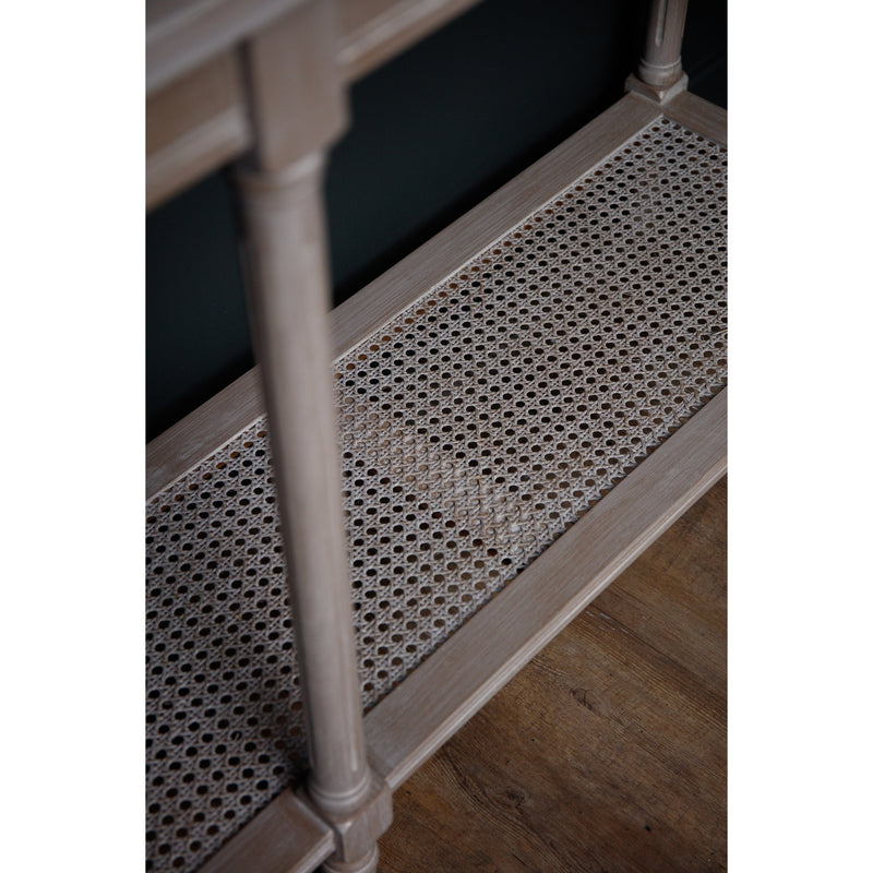 Woven rattan lower shelf of the grey console table