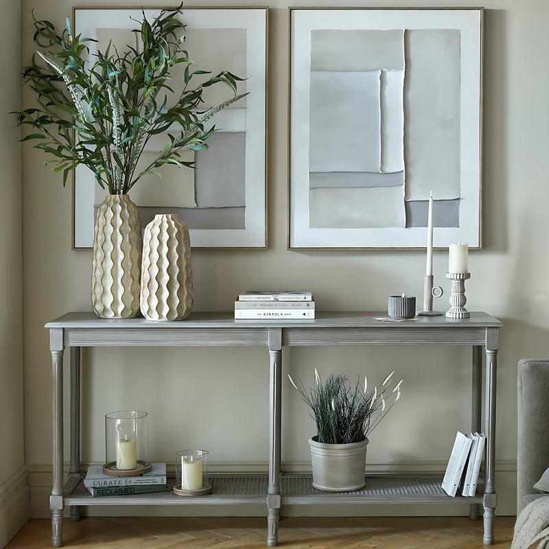 Large grey console table styled with plants and wall art