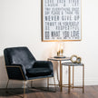 black marble nesting tables beside a velvet armchair