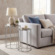 pair of mirrored side tables beside a sofa with a lamp