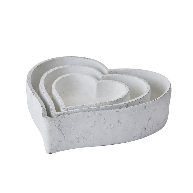Set of three matt white ceramic heart dishes nested together
