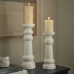Sile candle holders with lit pillar candles on a dark sideboard, shown with the large size sold separately